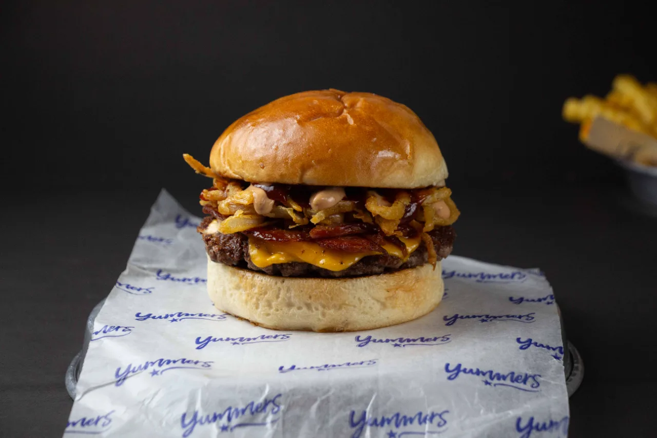 Hamburguesa con cheddar, panceta y cebolla crocante de Yummers — fotografía gastronómica